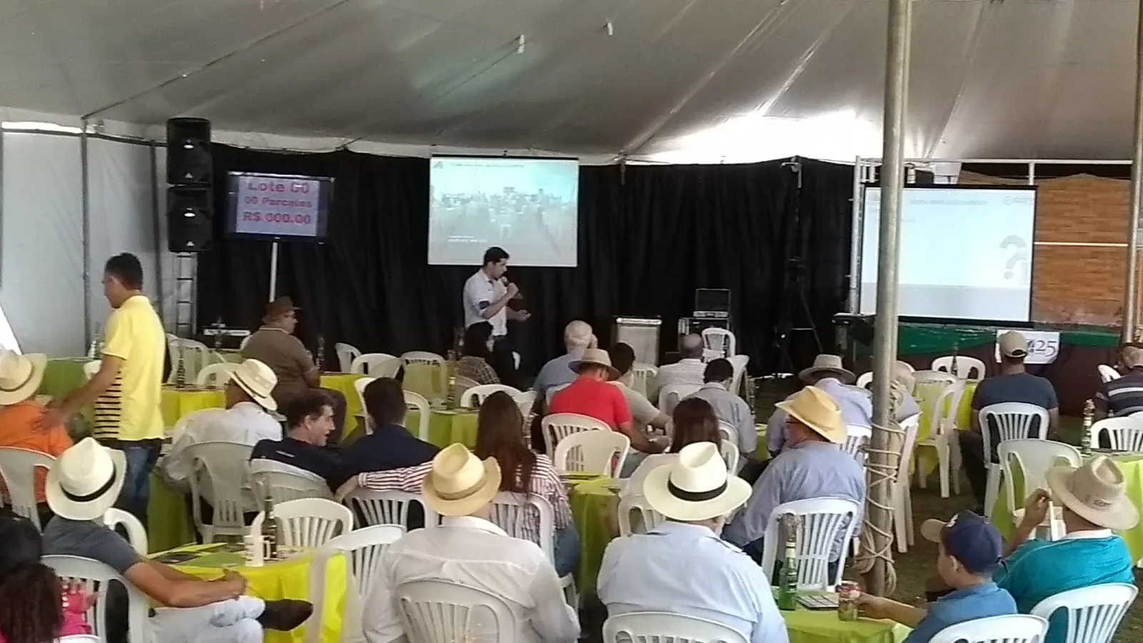 Produtores de chapéu assistindo a uma palestra na tenda da feira